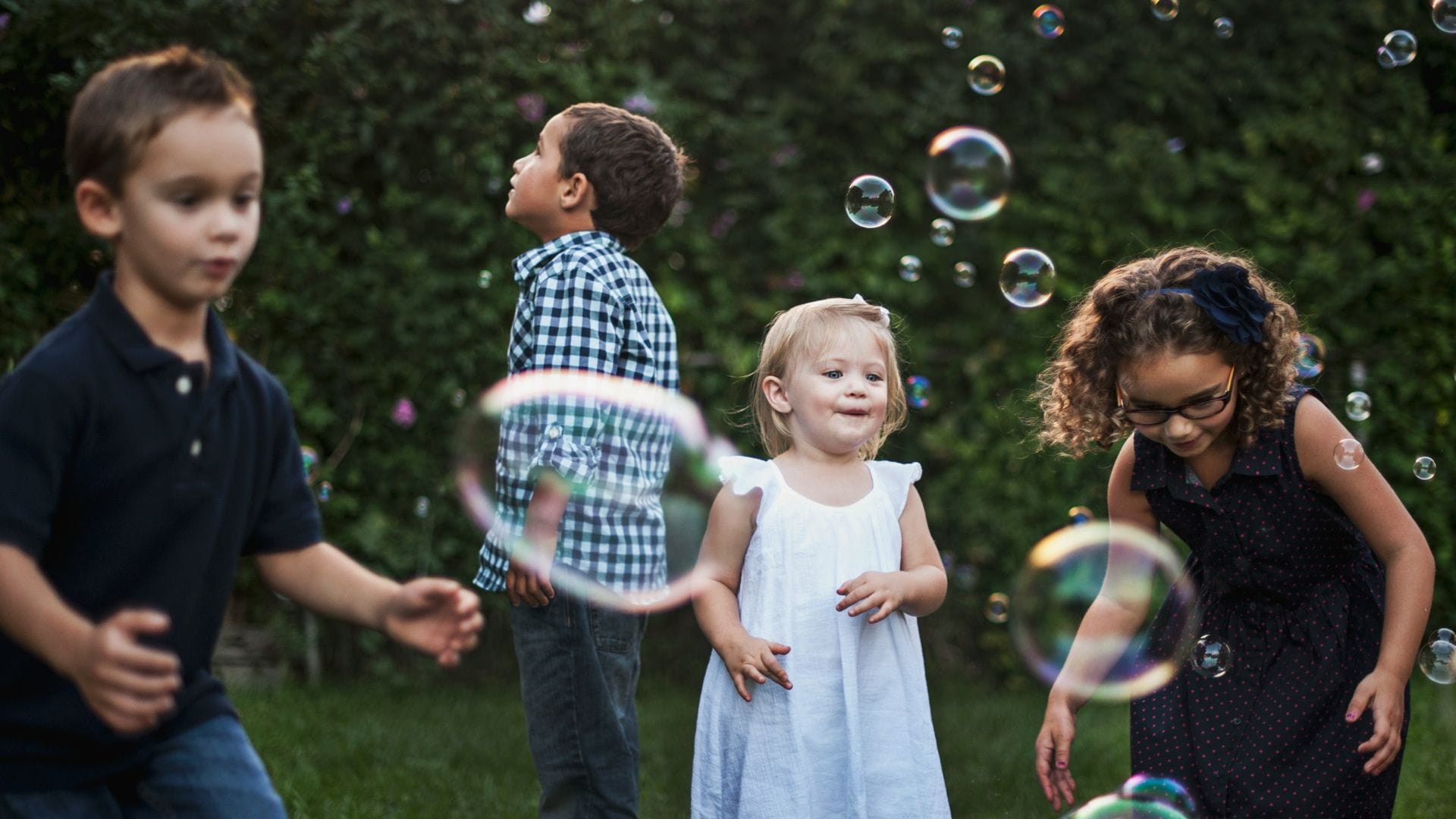 kinder spielen zusammen mit Seifenblasen