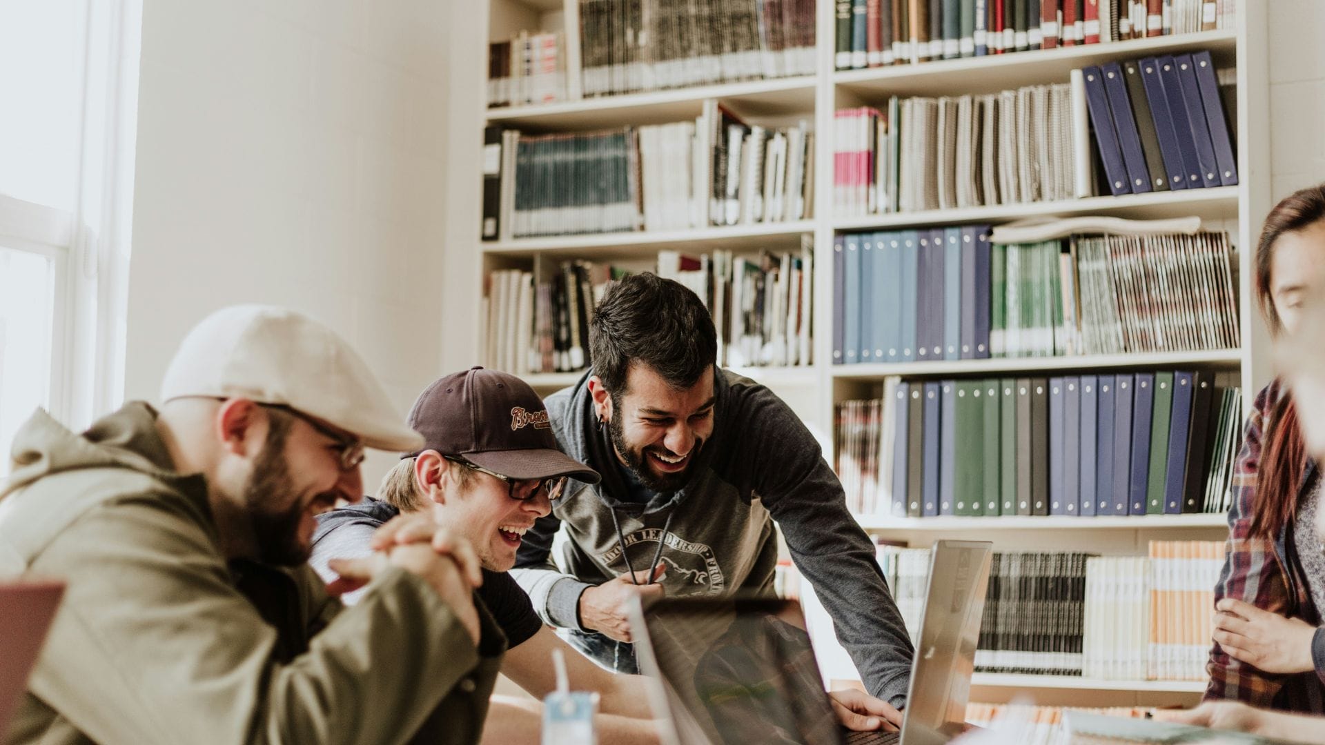 vier menschen sitzen zusammen und arbeiten an laptops